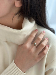 Women in white turtle neck with hand on shoulder, displaying silver jade and pearl ring