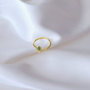  jade and pearl ring laying sideways on cloth