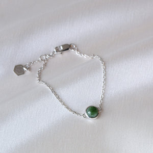 Closeup of silver jade bracelet on cloth