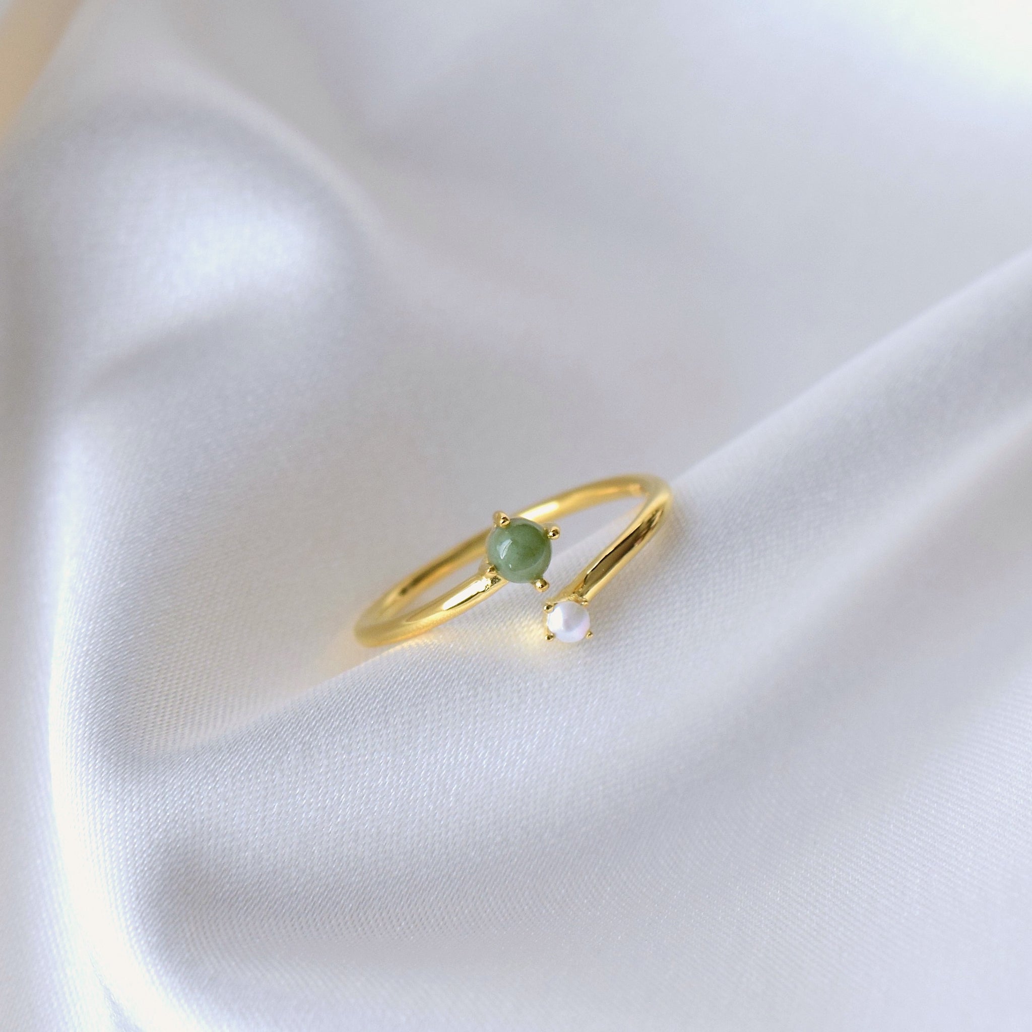 Closeup of jade and pearl ring on cloth