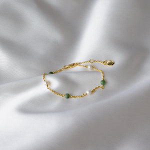 Gold Jade and Pearl Bracelet displayed on cloth