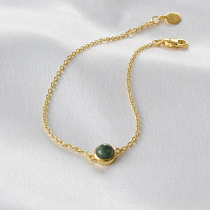 Closeup of gold jade bracelet on cloth