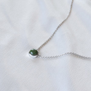 Closeup of silver jade necklace on cloth