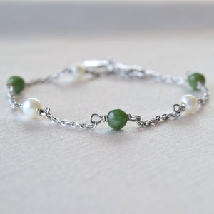 Closeup of silver jade and pearl bracelet on cloth