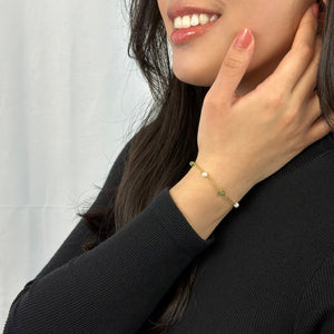 Gold Jade and Pearl Bracelet worn by woman in black dress 