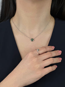 Woman wearing black dress displaying silver jade necklace and silver jade and pearl ring