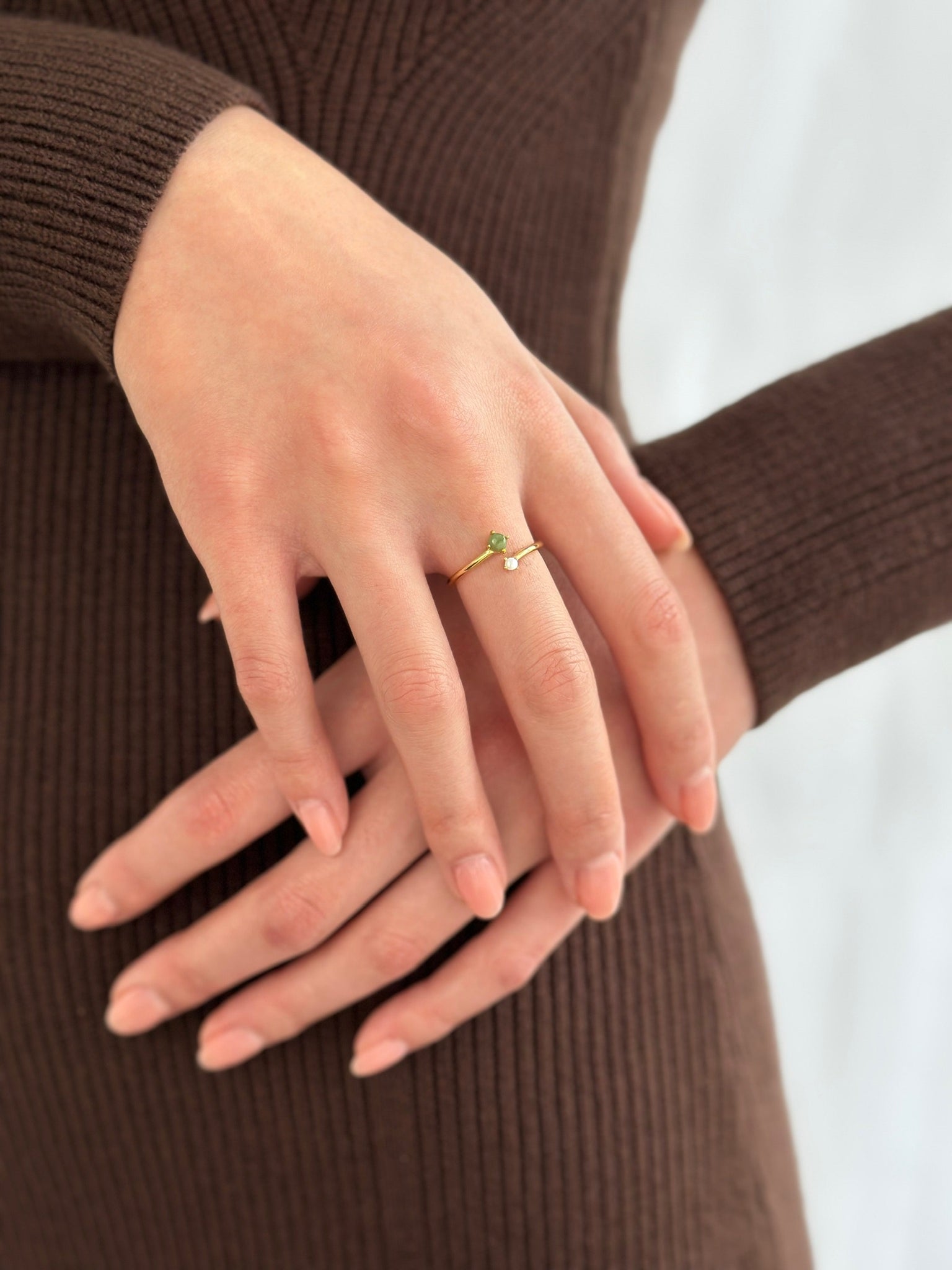 Woman wearing brown dress displaying gold jade and pearl ring